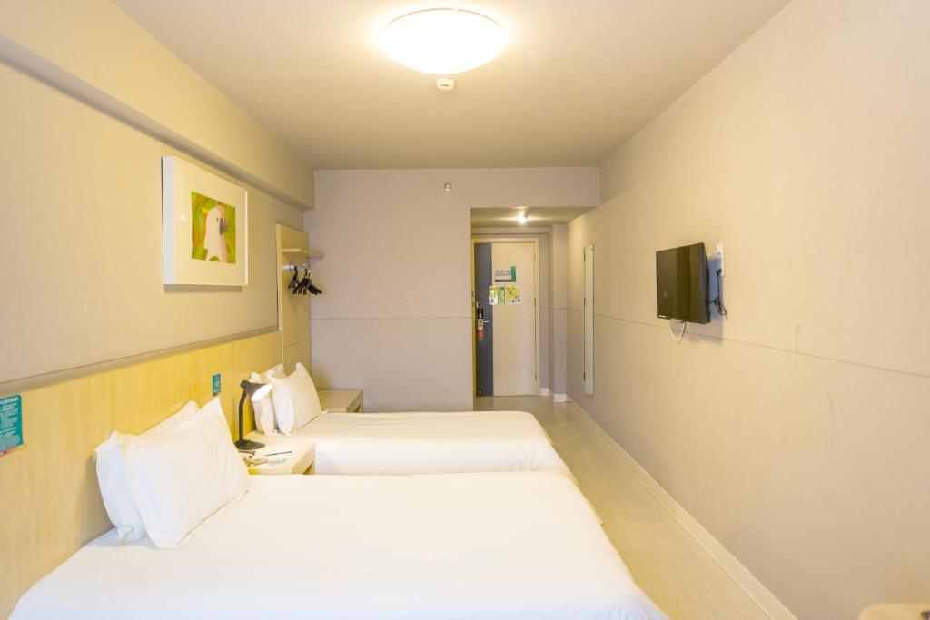 een hotelkamer met 2 bedden en een televisie bij Jinjiang Inn Hefei Jinzhai Road Zhongke Hotel in Hefei