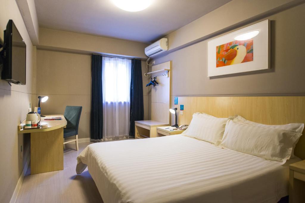 a hotel room with a bed and a window at Jinjiang Inn Select Wuhan Guangfutun Metro Station in Wuhan