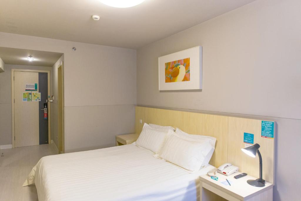 1 dormitorio con 1 cama y 1 lámpara en una mesa en Jinjiang Inn Select Yan'an Zaoyuan Road, en Yan'an