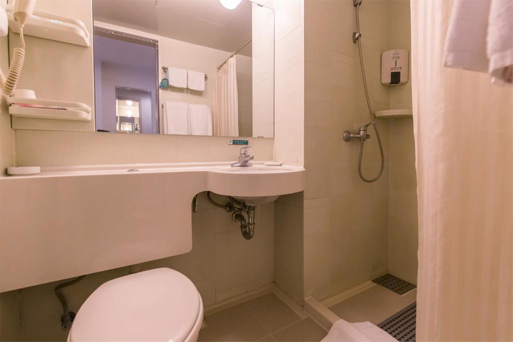 een badkamer met een toilet, een wastafel en een spiegel bij Jinjiang Inn Select Suqian Bus Terminal in Suqian