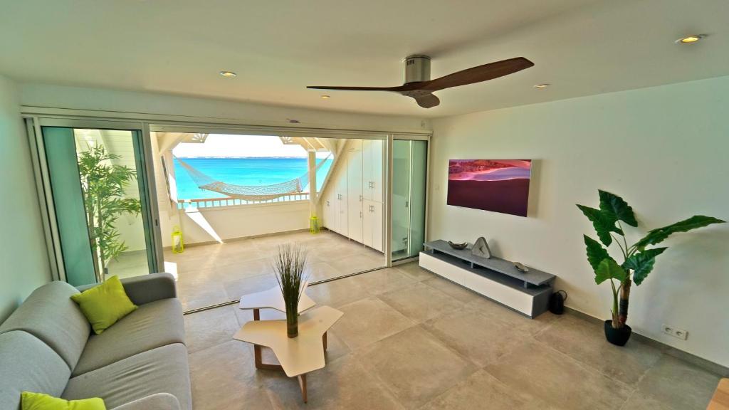 a living room with a couch and a ceiling fan at Grand Case Beach in Grand Case