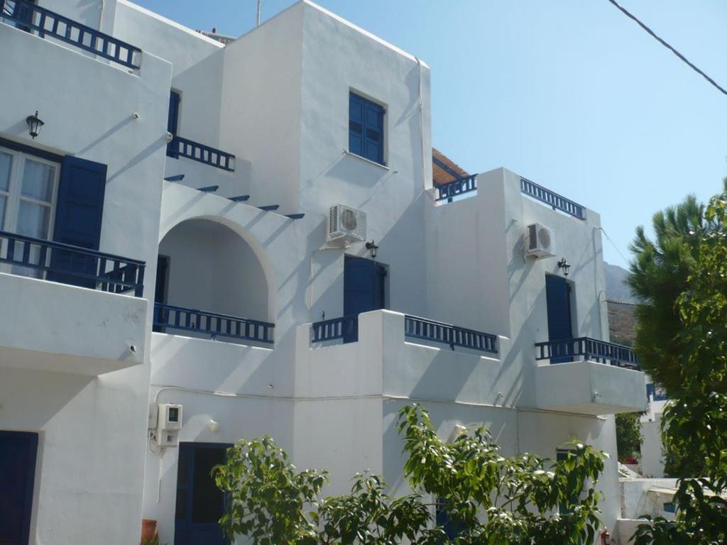 a white building with blue doors and windows at Elichryson Studios in Aegiali