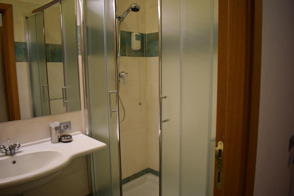 a bathroom with a glass shower and a sink at Hotel Baffo Rosso in Alba Adriatica