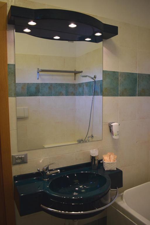 a bathroom with a green sink and a shower at Hotel Baffo Rosso in Alba Adriatica