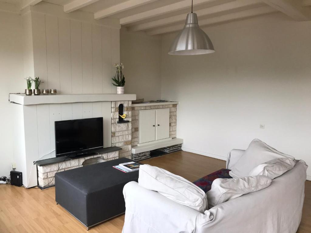 a living room with a couch and a tv at Appartement224 in Grimbergen