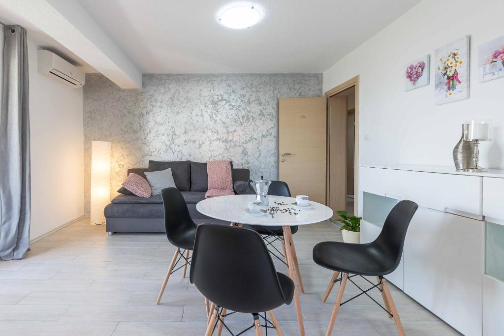 ein Wohnzimmer mit einem Tisch, Stühlen und einem Sofa in der Unterkunft Apartments Villa Tre Marie in Rovinj