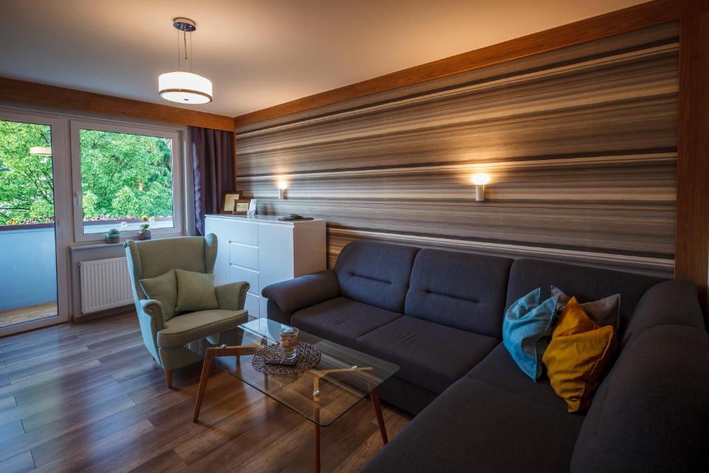 - un salon avec un canapé et deux chaises dans l'établissement Apartament Makuszynsky, à Zakopane