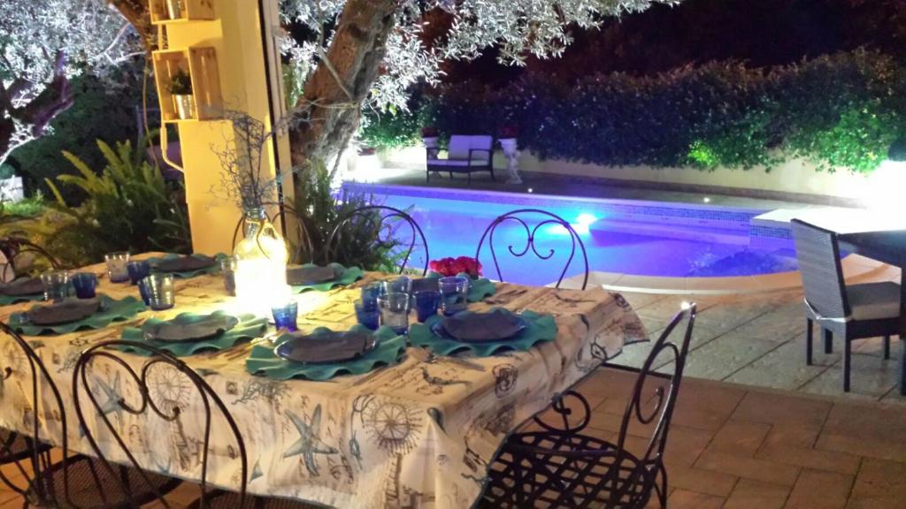 une table et des chaises avec une table et une piscine dans l'établissement Villa Degli Ulivi, à Santa Maria del Cedro
