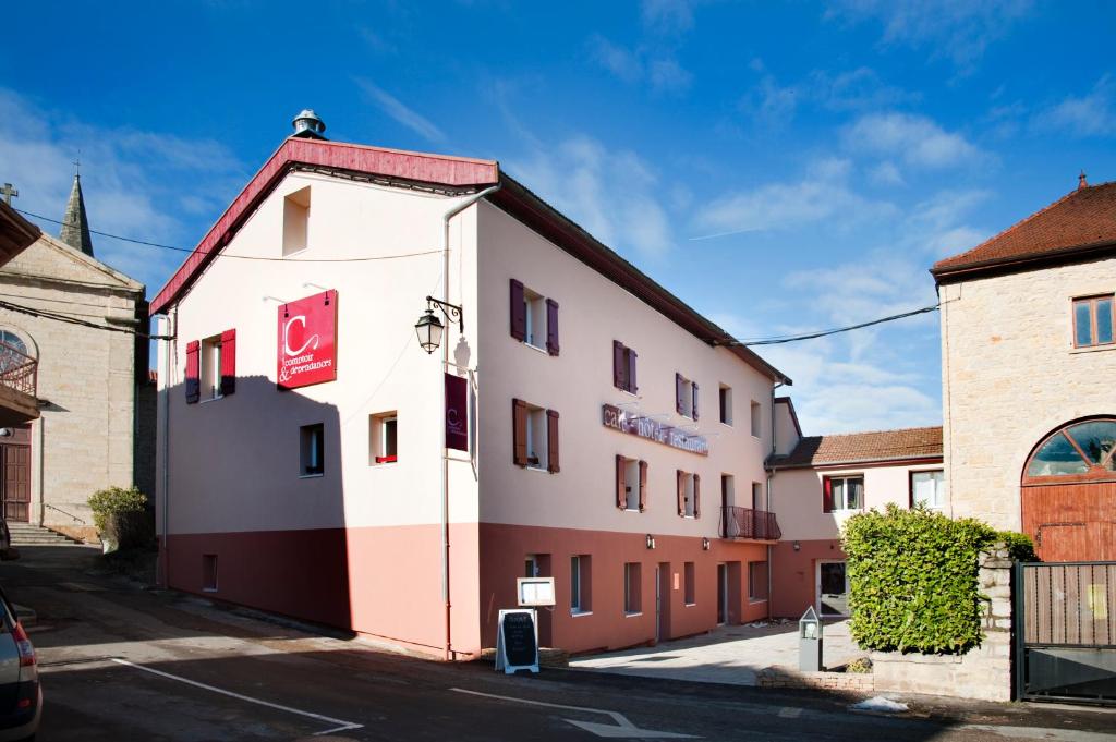 Frontonas的住宿－孔圖恩德拜酒店，一座白色和红色的建筑,毗邻一座建筑