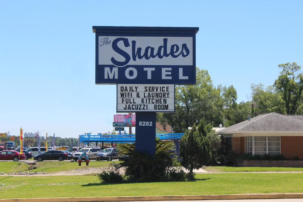 ein Schild für ein schattiges Motel auf einem Parkplatz in der Unterkunft The Shades Motel in Baton Rouge