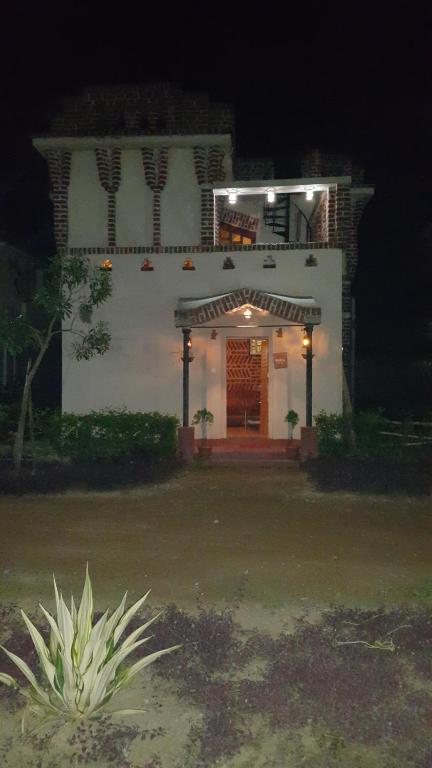 ein Haus in der Nacht mit einer beleuchteten Tür in der Unterkunft Shantiniketan Bungalow in Bolpur