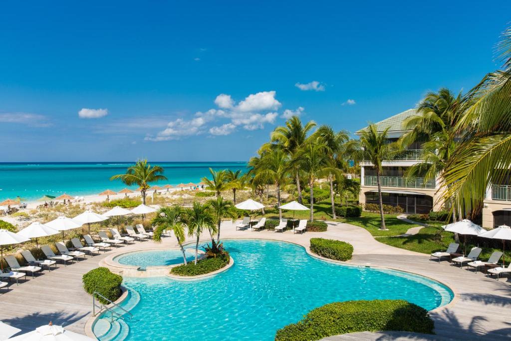 uma vista aérea do resort com piscina e praia em The Sands at Grace Bay em Grace Bay