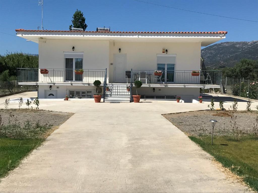 a large white house with a large driveway at Villa Filoxenia in Amarynthos