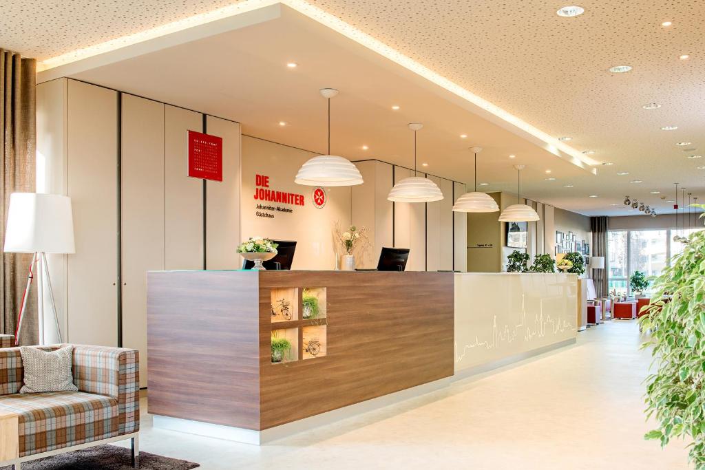 an office lobby with a reception desk and pendant lights at Johanniter Gästehaus in Münster