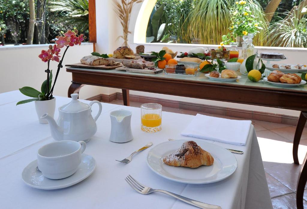 uma mesa com um prato de comida e café e uma mesa com um pequeno almoço em La Gaggia Guest House em Piano di Sorrento