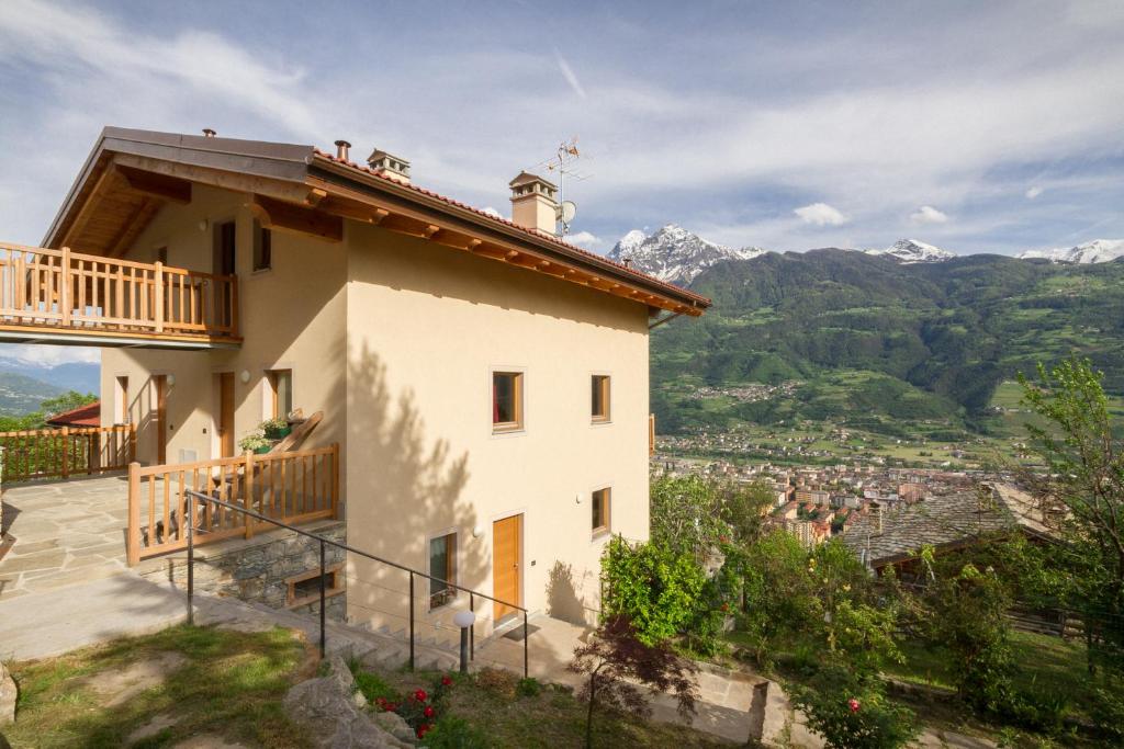 ein Haus mit Balkon und Bergen im Hintergrund in der Unterkunft La Casa di Alfredo e Virginia in Aosta