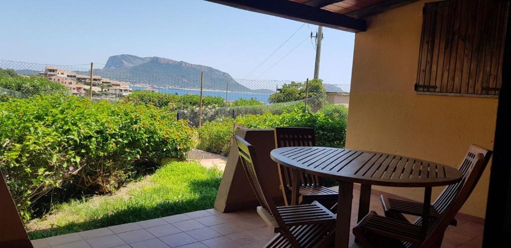 a wooden table and chairs on a balcony with a view at Residence Spiaggia Bianca in Golfo Aranci