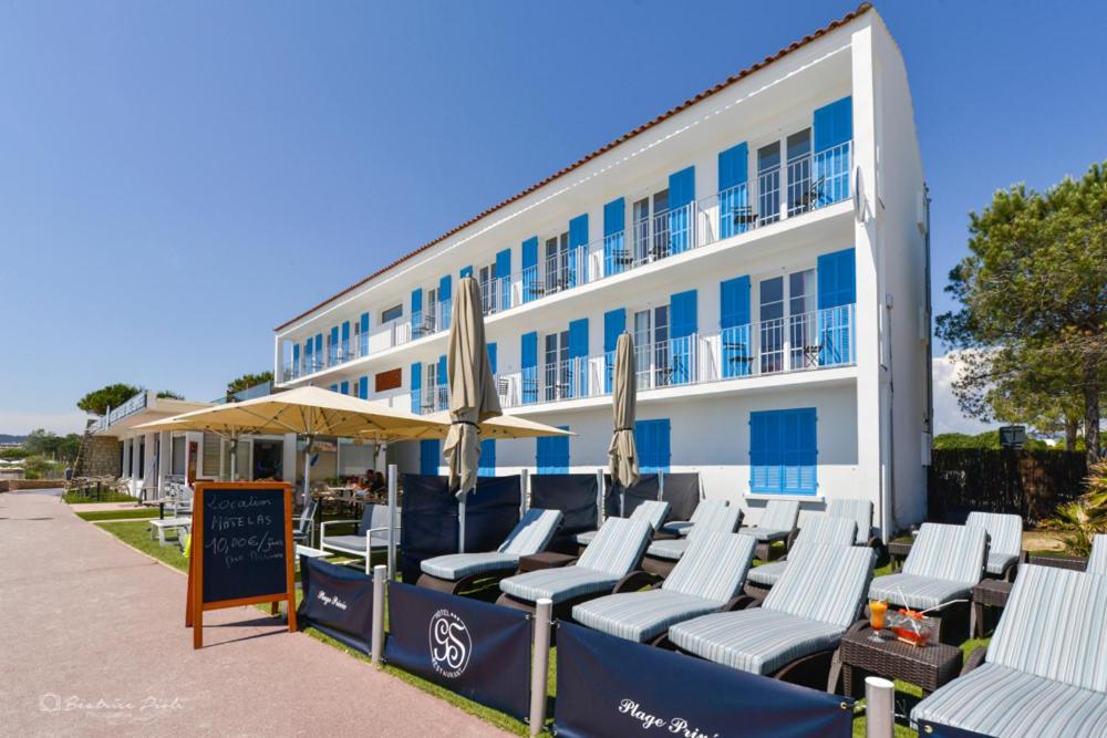 a row of lounge chairs in front of a building at Hôtel George Sand in La Seyne-sur-Mer