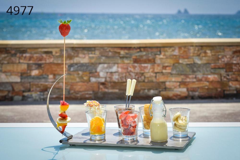 a tray with fruit and drinks on a table at Hôtel George Sand in La Seyne-sur-Mer