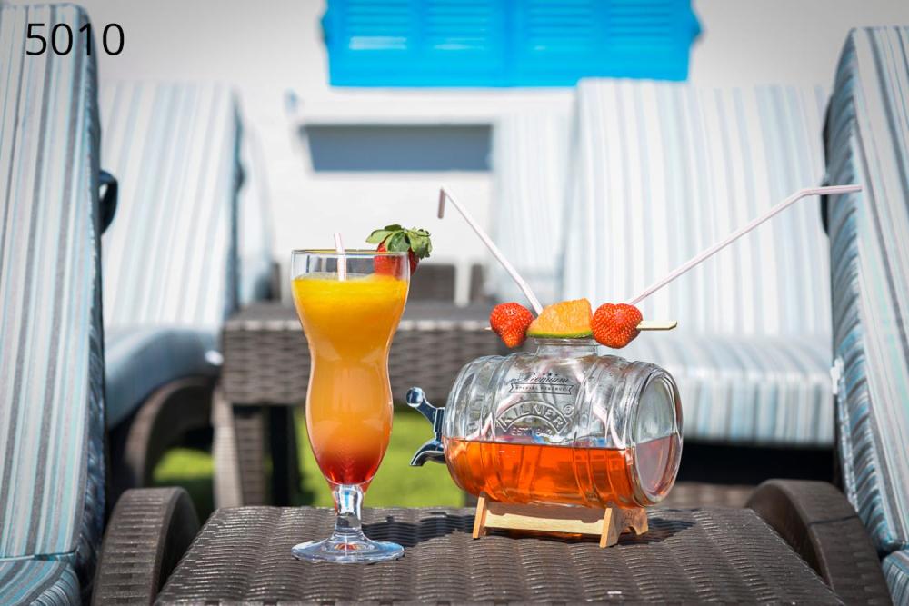 a drink and a vase on a table at Hôtel George Sand in La Seyne-sur-Mer