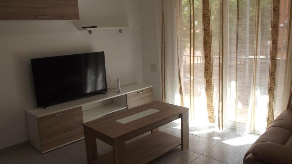 uma sala de estar com uma televisão e uma mesa de centro em Apartamentos Atlas Terrassa III em Terrassa