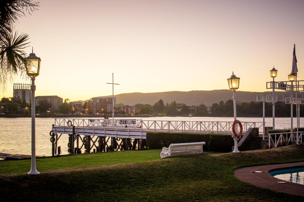 a pier next to a body of water with two lights at Villa del Rio Express in Valdivia
