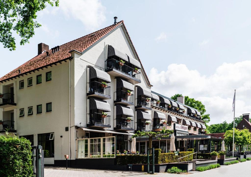 a large white building with balconies on a street at Hotel 't Paviljoen in Rhenen