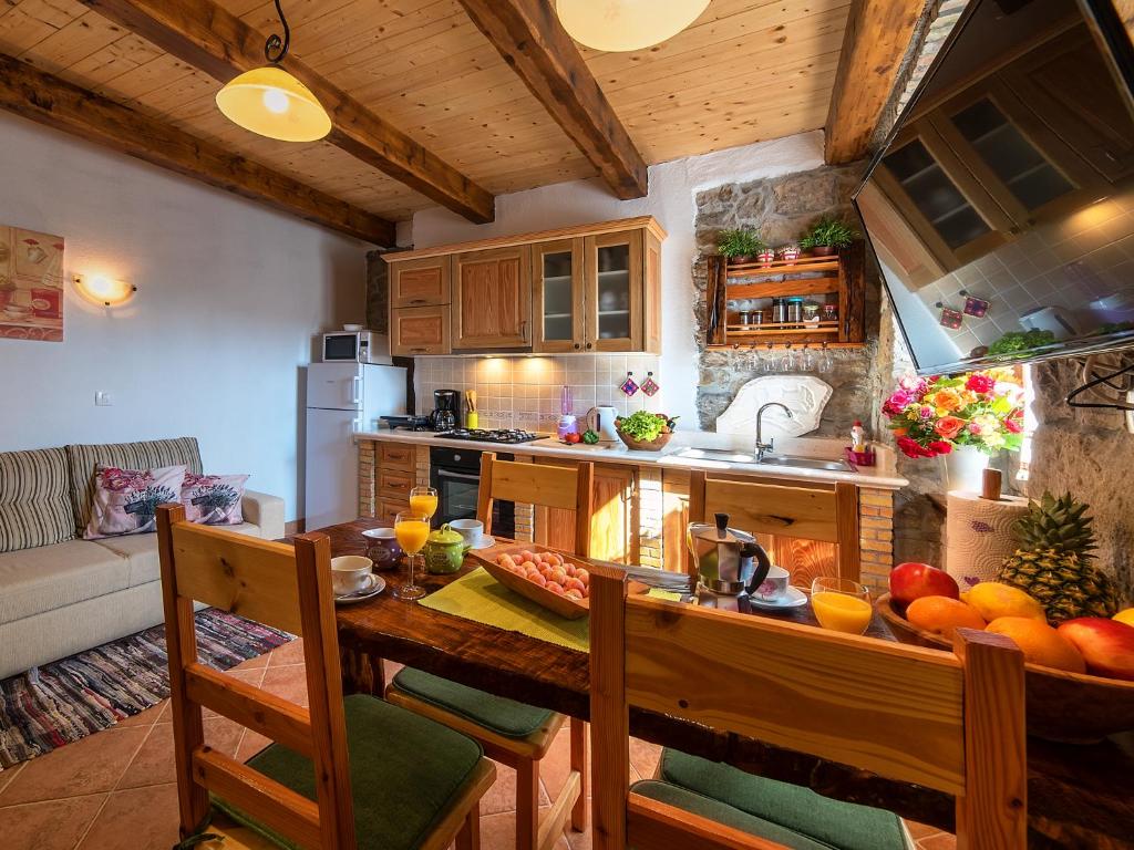eine Küche mit einem Holztisch und einem Esszimmer in der Unterkunft Apartments Roža in Roč