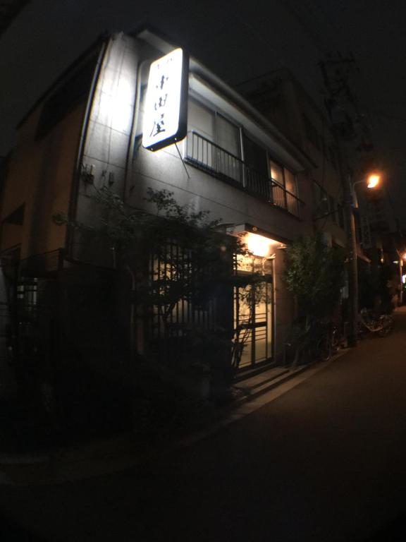 a sign on the side of a building at night at Ryokan Nakadaya in Tokyo