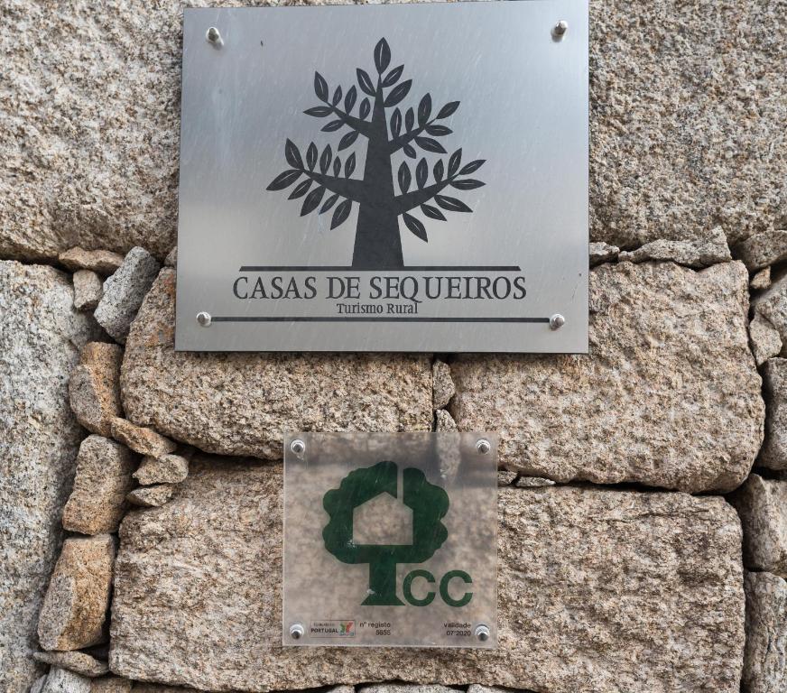 a sign on the side of a stone wall at Casas de Sequeiros in Sequeiros