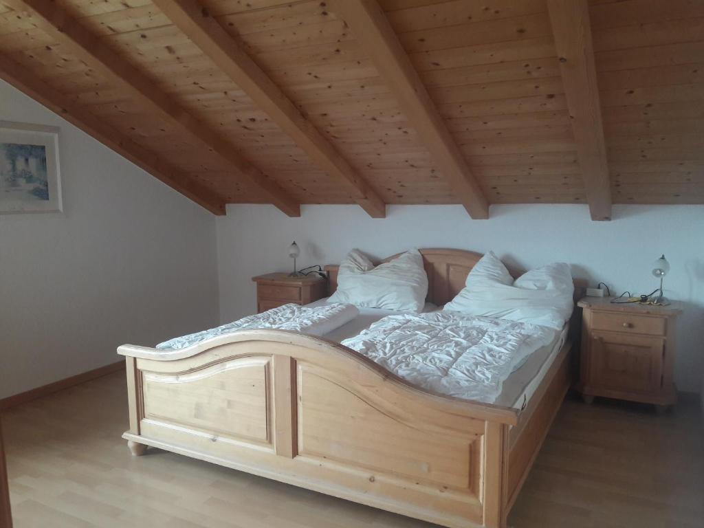 ein Holzbett in einem Zimmer mit Holzdecke in der Unterkunft Hofschank Reinalterhof in Mals im Vinschgau
