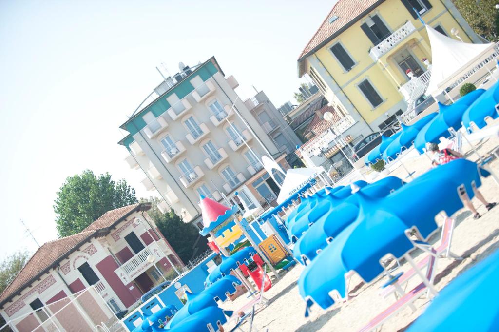 un gruppo di sedie blu su una spiaggia di Hotel Alsen a Rimini