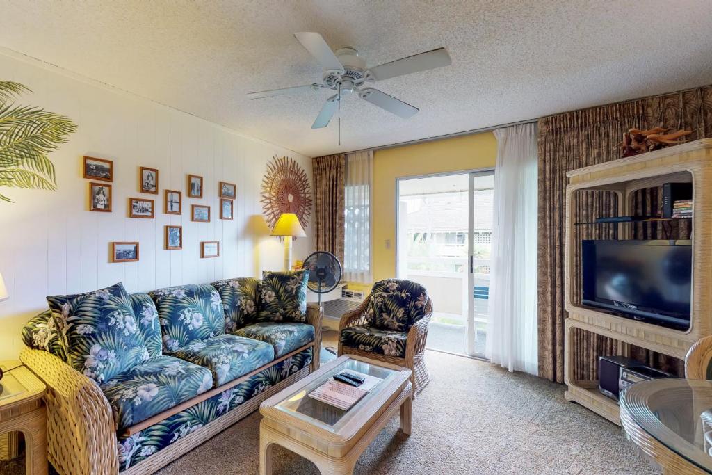 a living room with a couch and a tv at Plantation Hale G14 in Kapaa