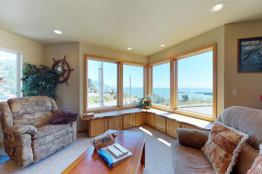 a living room with a couch and a table and windows at Coast Haven in Port Orford