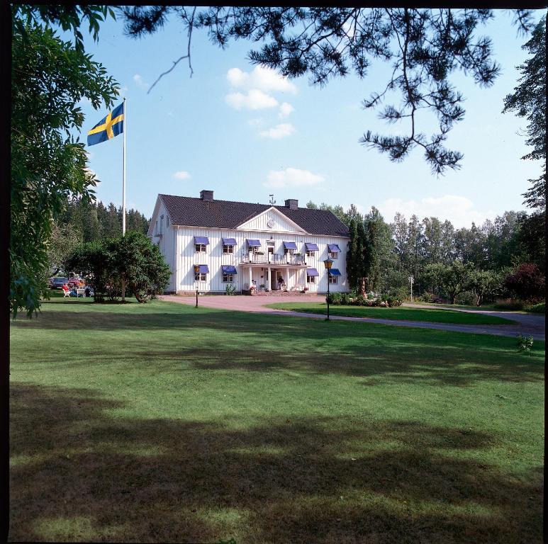 a flag flying in front of a large building at Gylleby Vandrarhem in Sunne