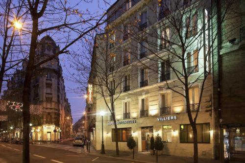un bâtiment situé dans une rue de la ville la nuit dans l'établissement Hotel B Square, à Paris