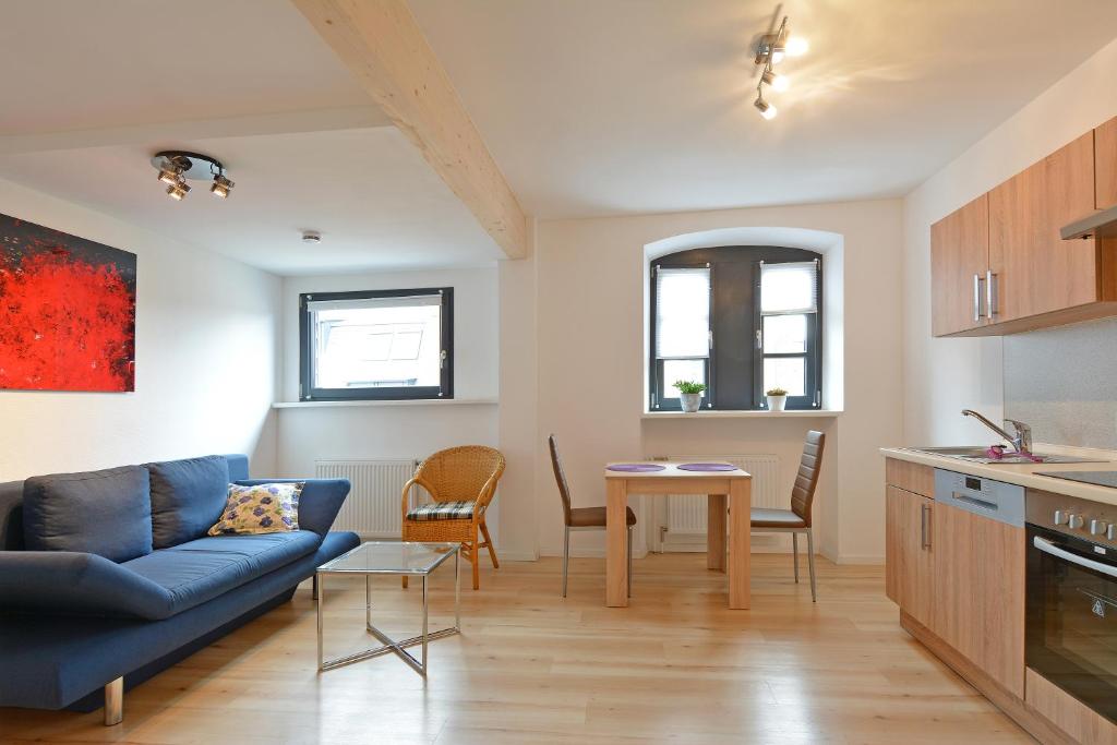 a living room with a blue couch and a table at FeWo Kröger in Trier