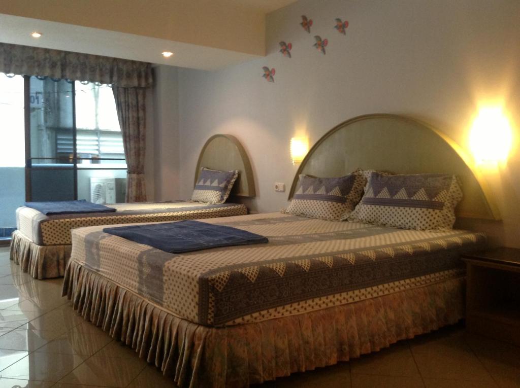 a bedroom with two beds with blue blankets and pillows at Pension Zum Ross in Karon Beach