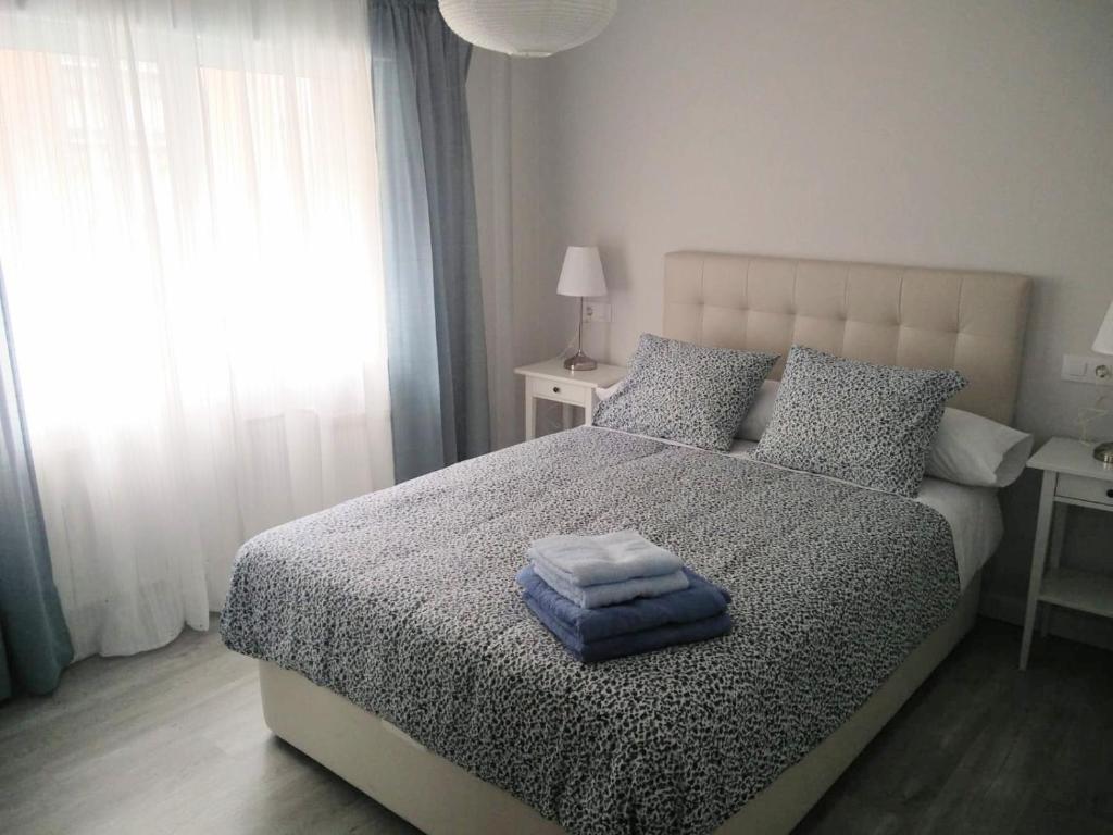 a bedroom with a bed with two towels on it at San Lorenzo House in Gijón
