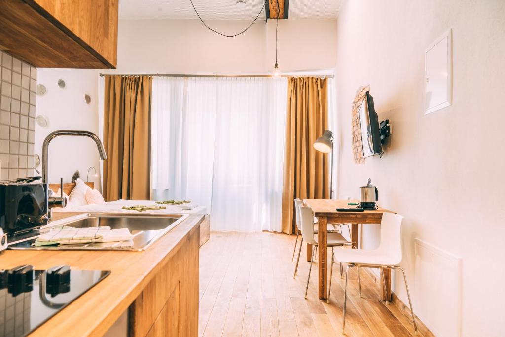 a kitchen with a counter and a table with chairs at Amtshaus Gut Hügle Boutique Apartments in Bad Waldsee