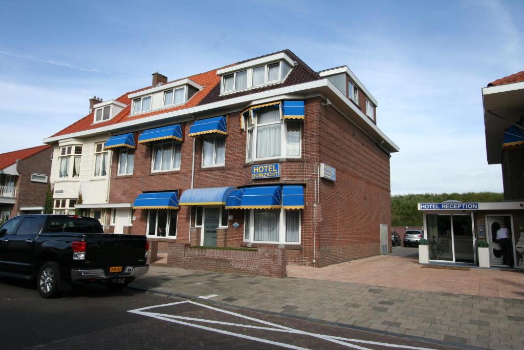 a building with a truck parked in front of it at Hotel Duinzicht in Scheveningen