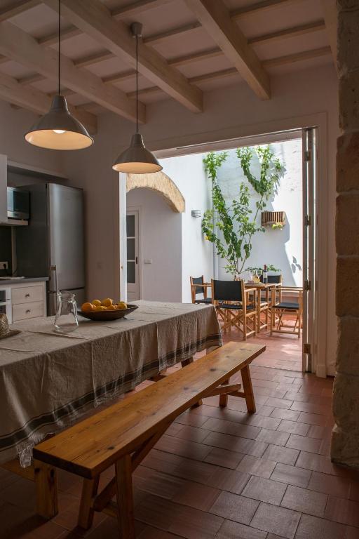 a kitchen with a table and a bench in a room at Cal Bisbe in Ciutadella