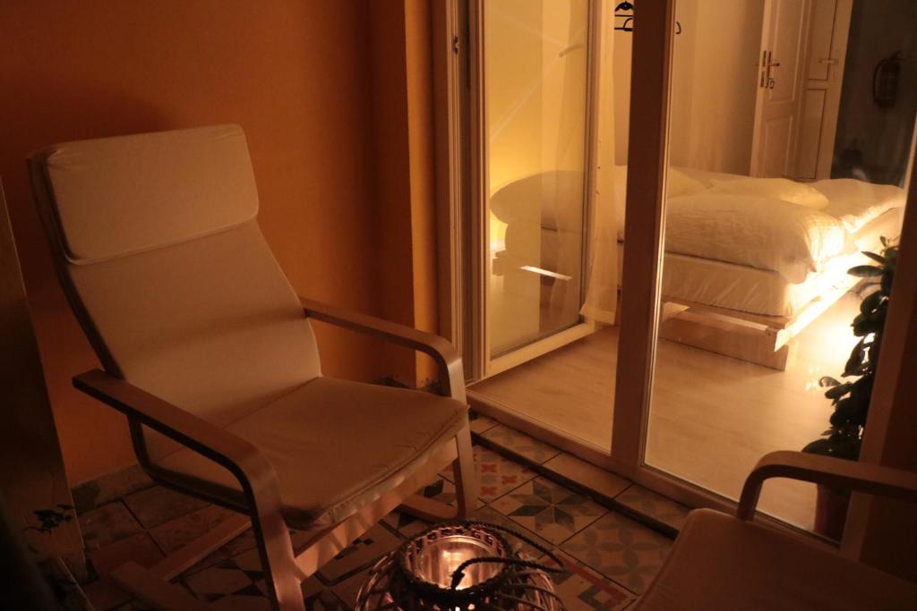 a white chair in a room with a bedroom at Hostel Sleeping Beauty in Ljubljana