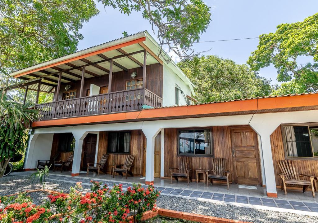 Casa antigua con balcón y sillas en Cabinas Arrecife, en Cahuita