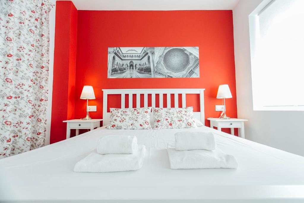 sypialnia z białym łóżkiem i czerwonymi ścianami w obiekcie Colorful and diaphanous- 3Bd 1Bth - Peral w Sewilli