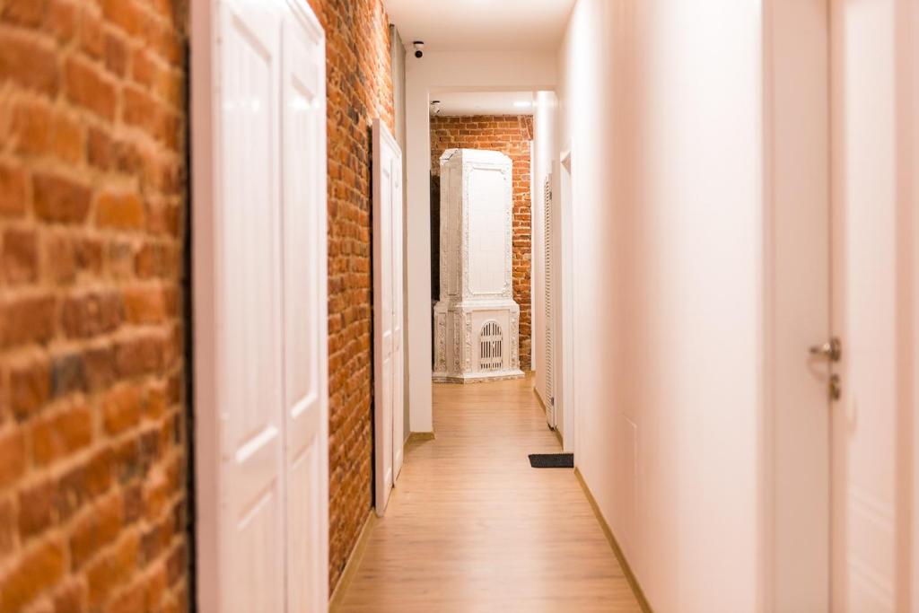 un couloir vide avec un mur en briques et un couloir en briques dans l'établissement Piotrkowska Studio Apartments, à Łódź