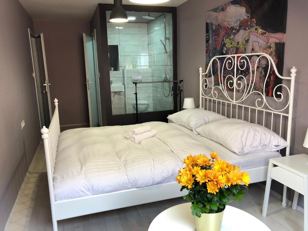 a bedroom with a white bed and a vase of flowers at Hostel Sleeping Beauty in Ljubljana