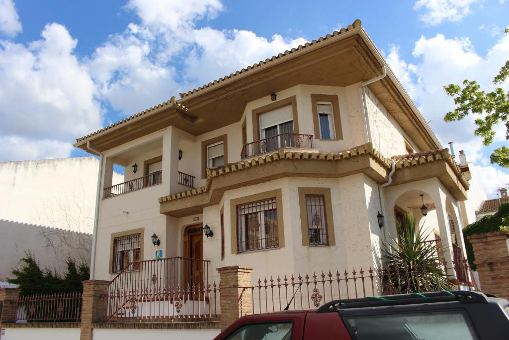Casa blanca con balcón en una calle en Villa Rural Campillo de Arenas, en Campillo de Arenas