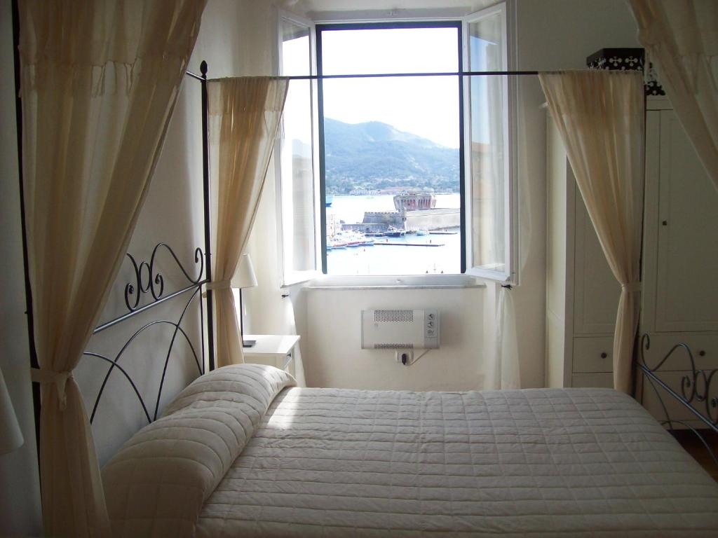 Schlafzimmer mit einem Bett und einem großen Fenster in der Unterkunft Porta del Mare in Portoferraio