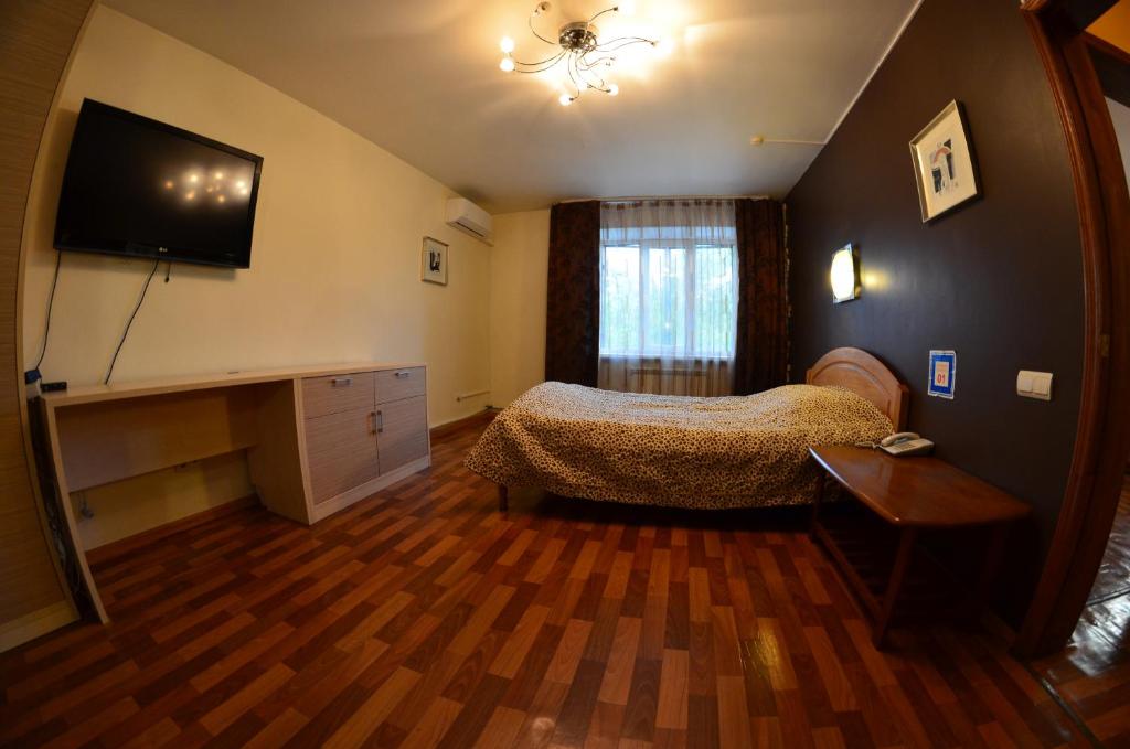 ウラジオストクにあるApartments on Russkaya 87 Меблированные Комнатыのベッドルーム(ベッド1台、薄型テレビ付)